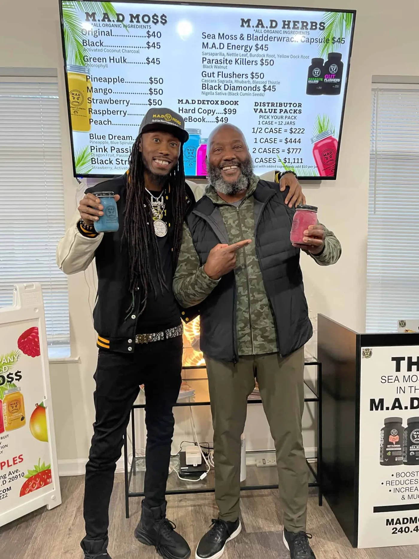 The founder with a customer in front of the M.A.D MOSS menu